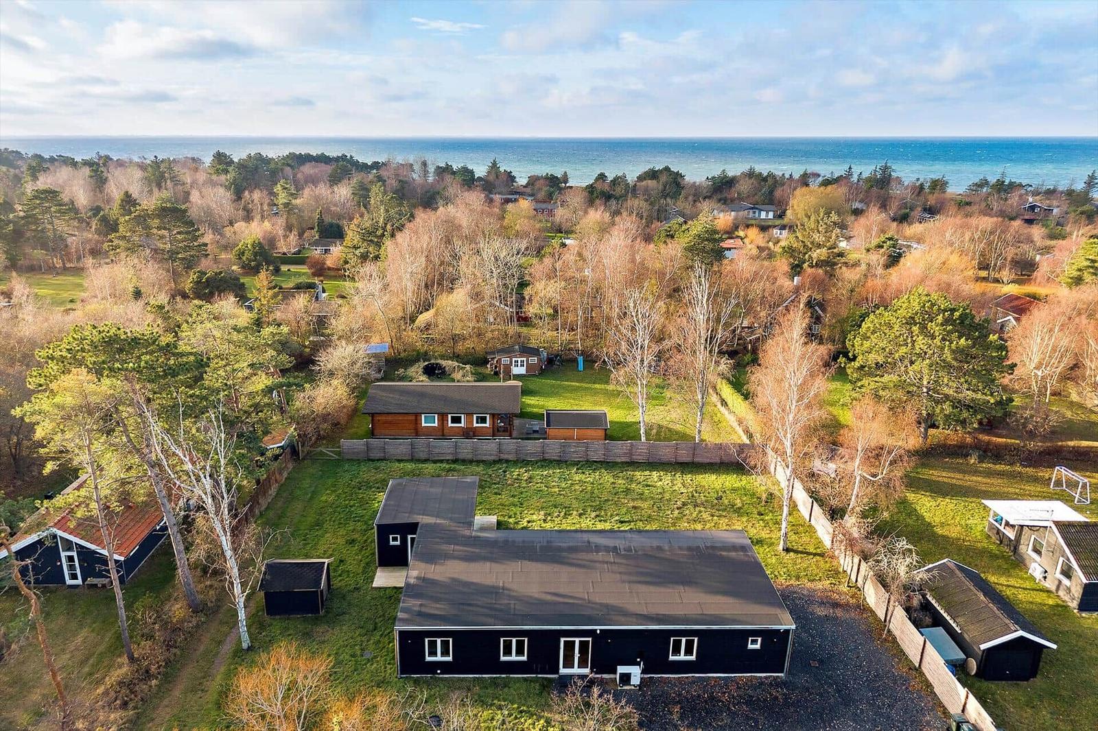 Schwarzes Haus mit Garten und Blick auf Meer und Wald.
