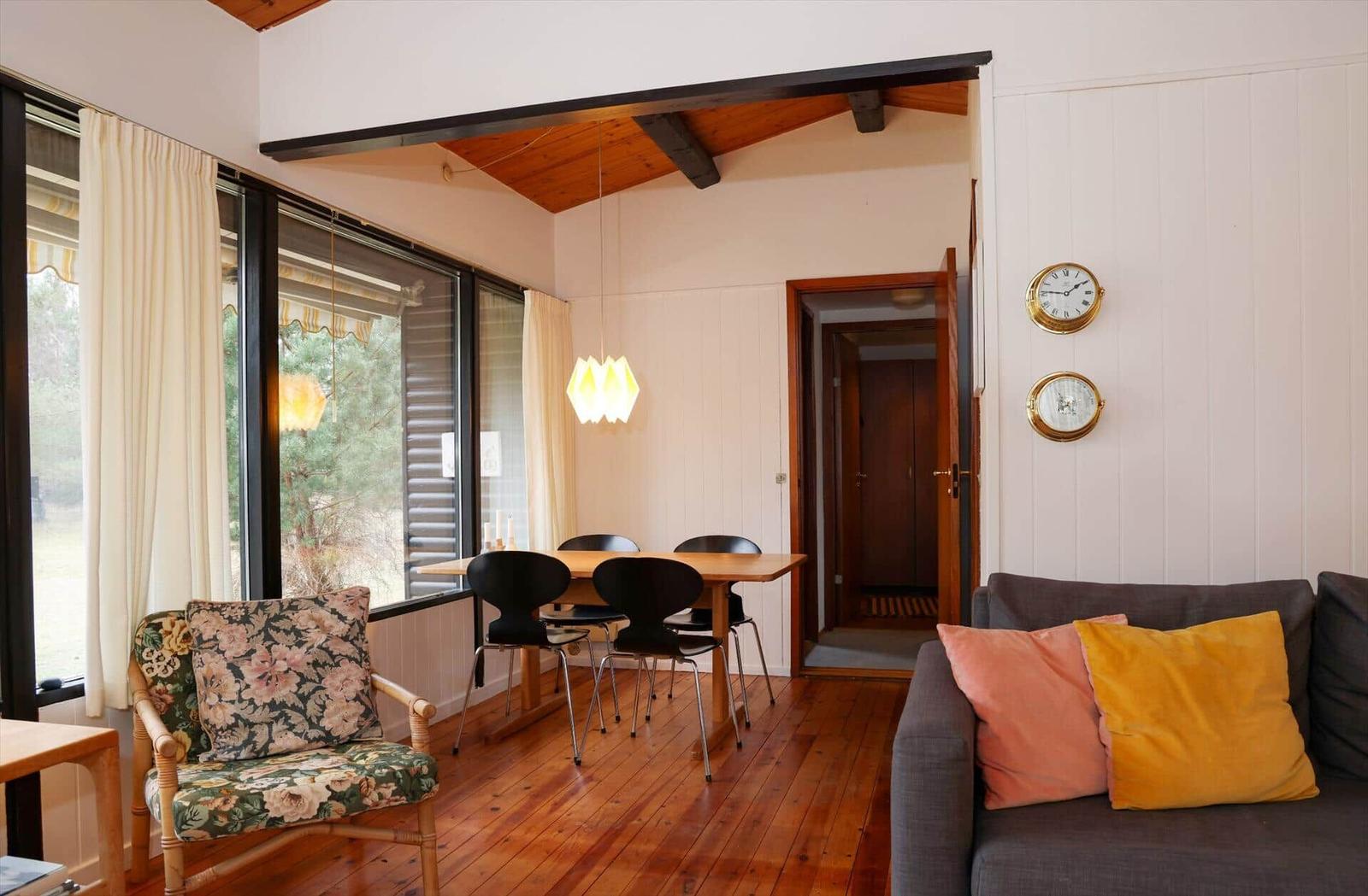 Living and dining area with wooden floor, sofa, chair, and table.