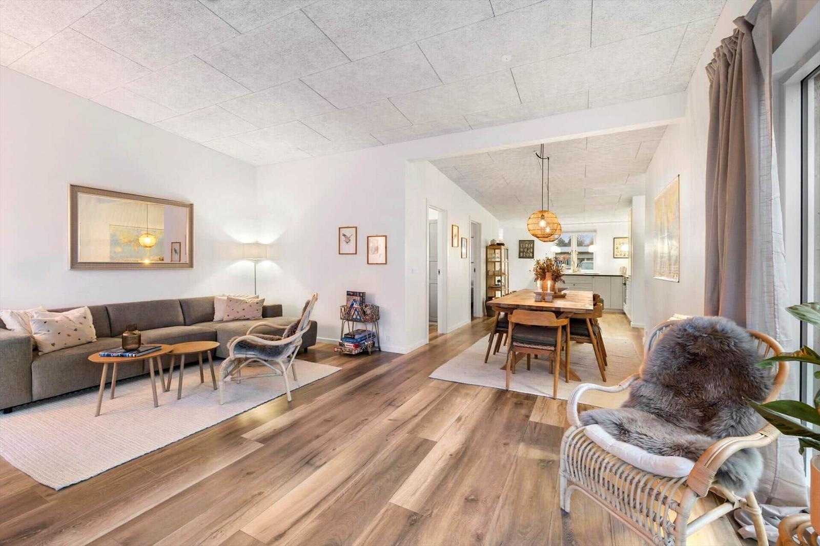 Living and dining area with wooden floor and modern furnishings.