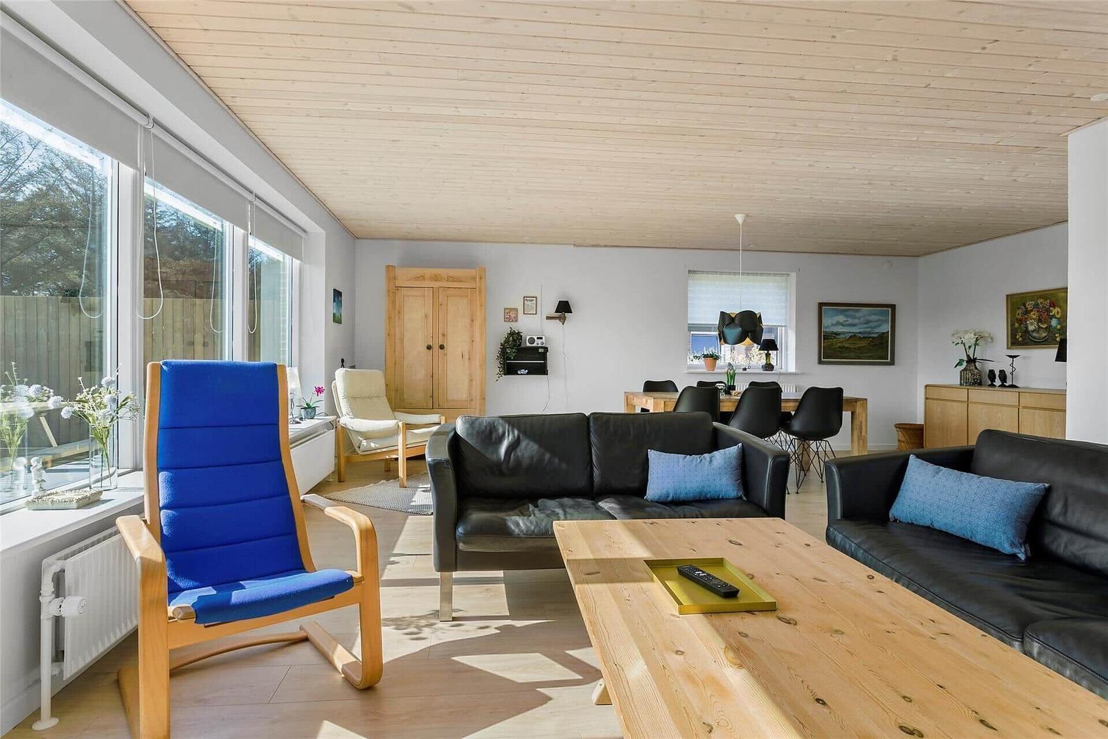 Wohn- und Essbereich mit Sofa, Couchtisch und blauer Sitzgelegenheit.