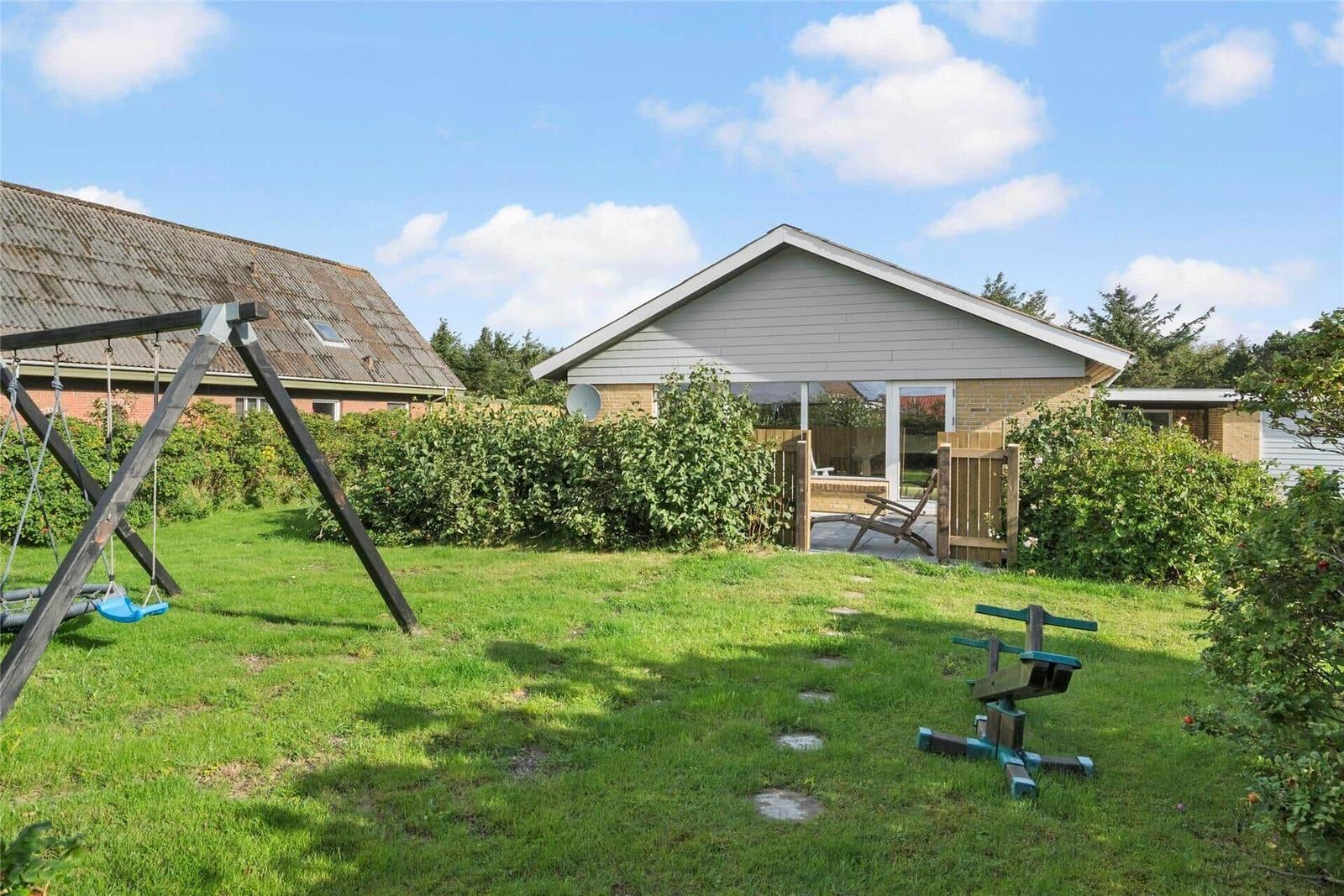 Haus mit Garten, Spielplatz und Terrasse im Hintergrund.