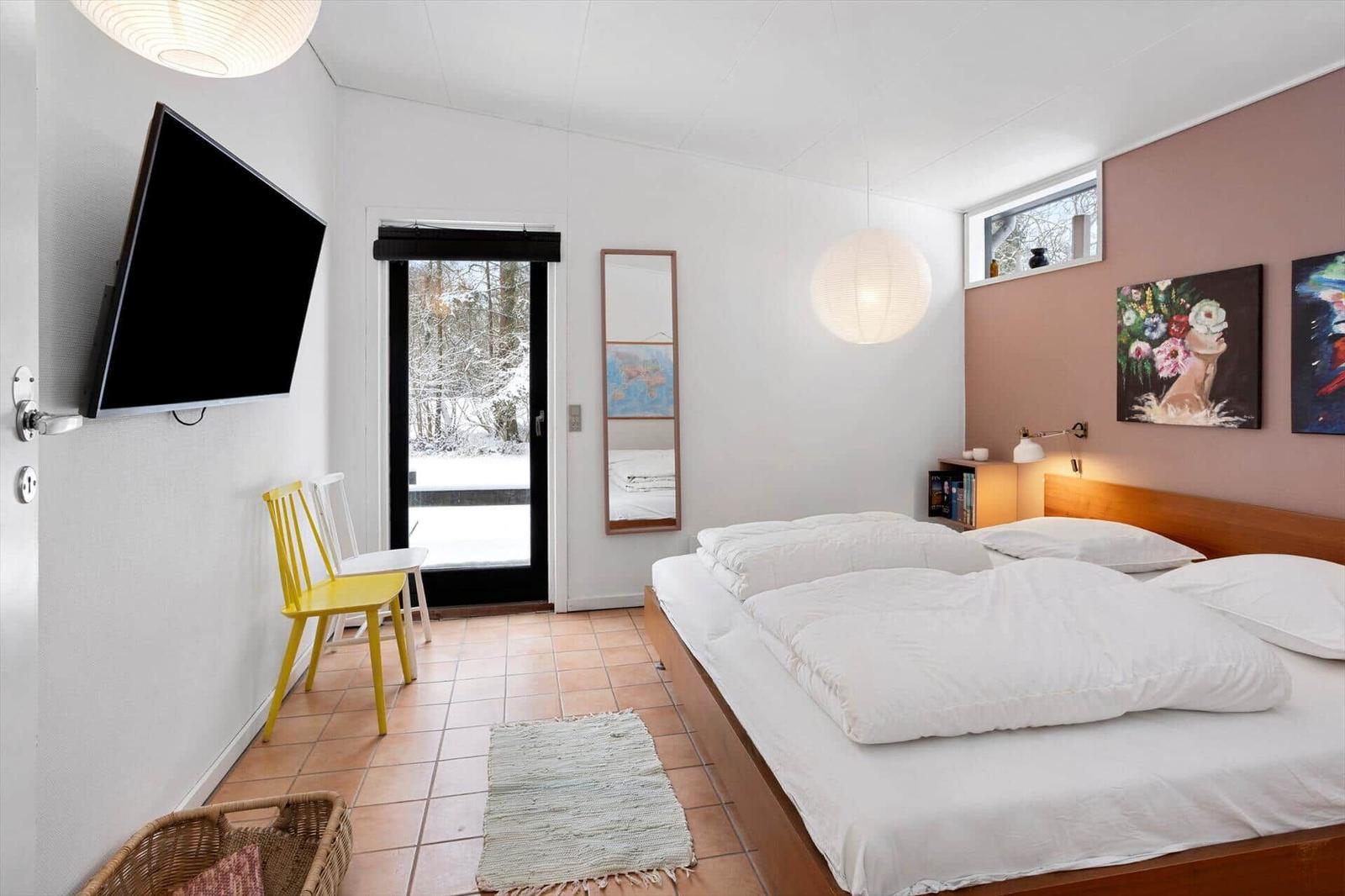 Bedroom with bed, TV, and view of snow