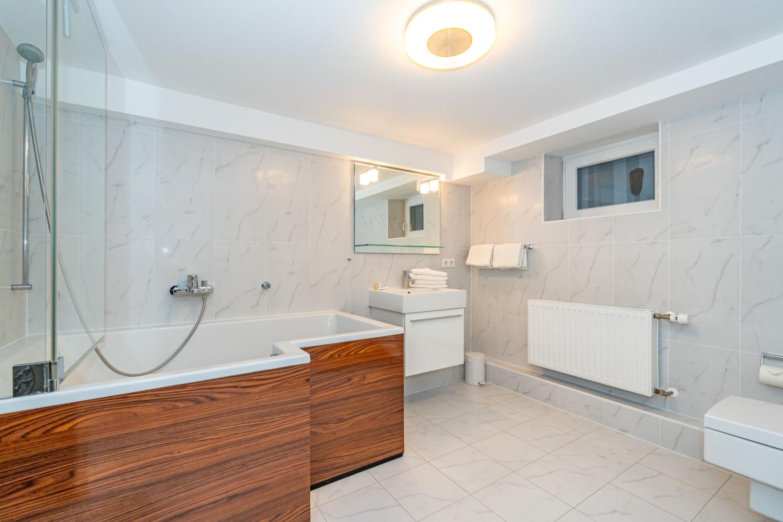 Bad mit Badewanne, Dusche, Waschbecken und Toilette.