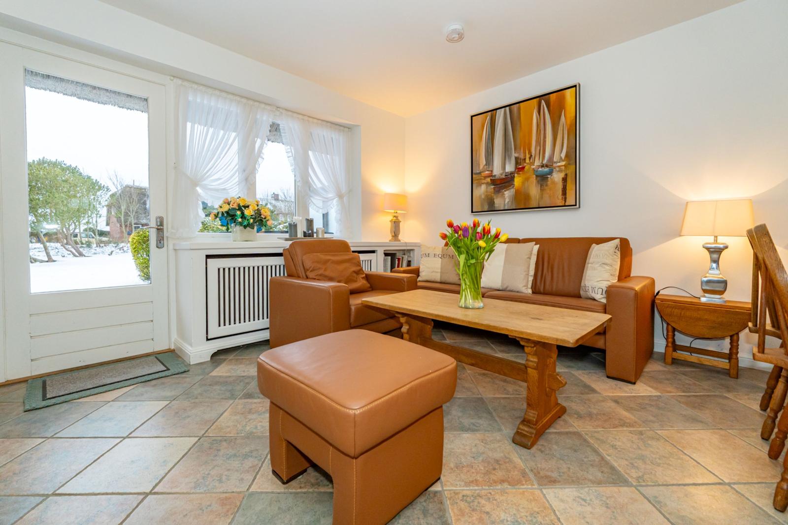 Wohnzimmer mit braunem Sofa, Holztisch und Fensterblick.