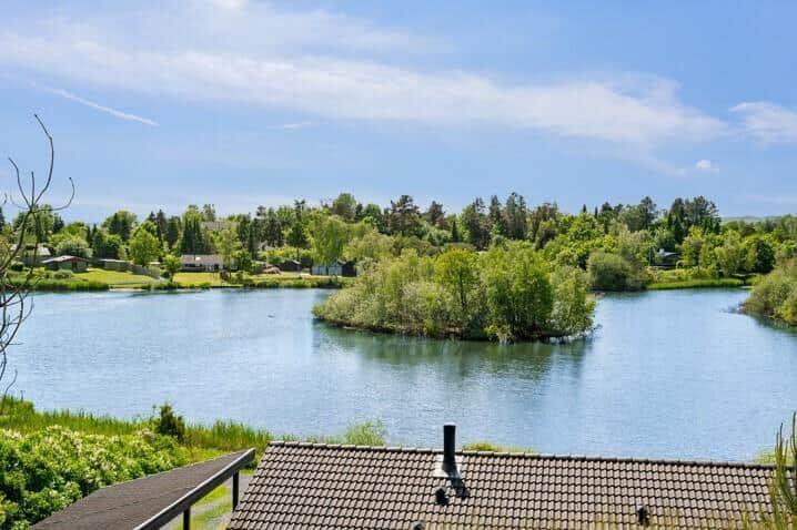 Blick auf einen See mit Insel und grüner Umgebung.
