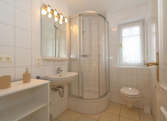 Badezimmer mit Dusche, Waschbecken und Toilette.