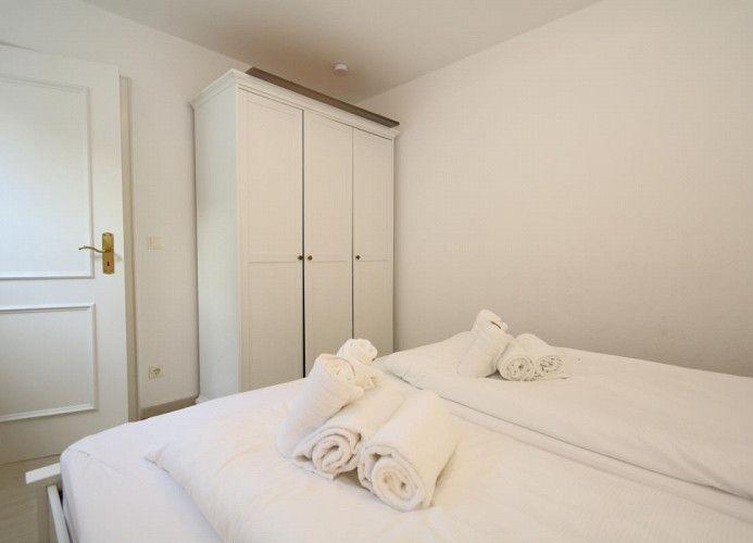 Schlafzimmer mit Bett, Kleiderschrank und Tür