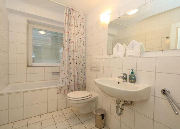 Badezimmer mit Badewanne, WC und Waschbecken.