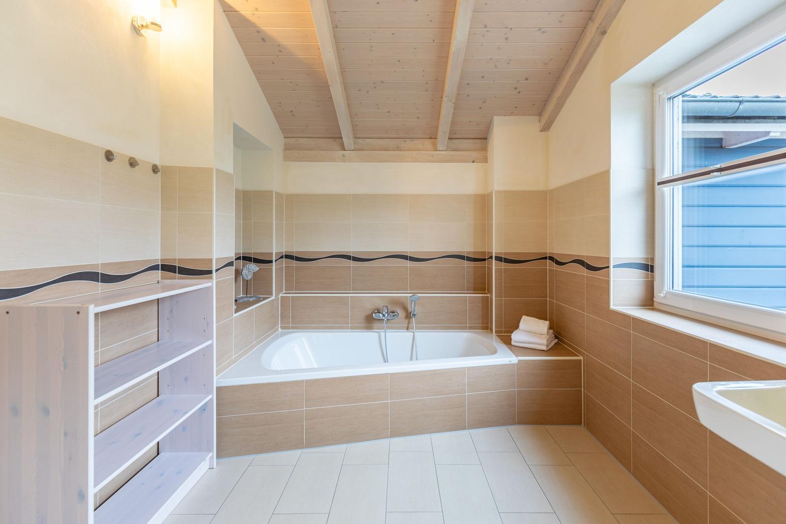 Bad mit Badewanne, Fenster und Holzdecke
