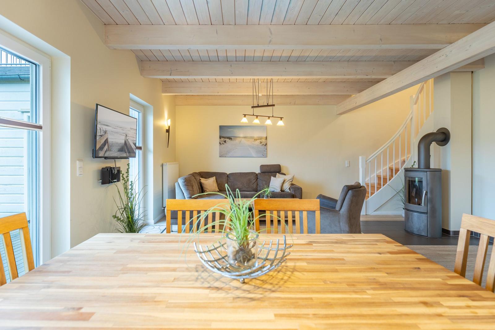 Essbereich mit Holztisch, Wohnbereich mit Sofa und Holzdecke