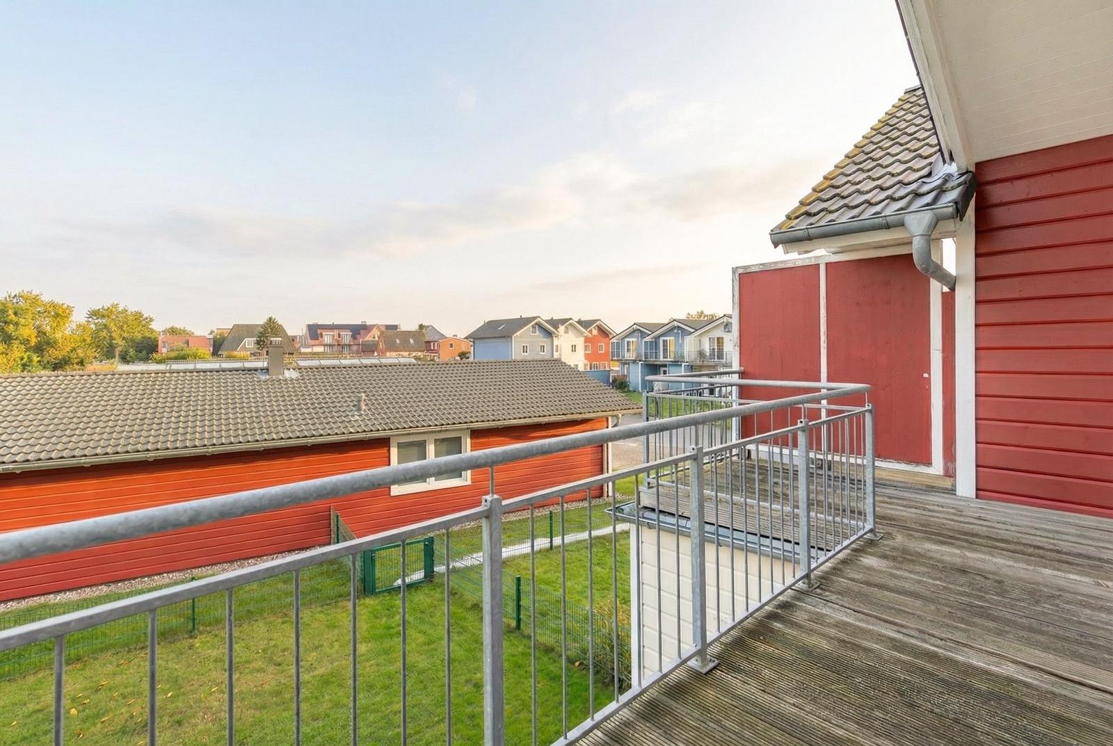 Terrasse mit Blick auf rote und blaue Häuser im Hintergrund.