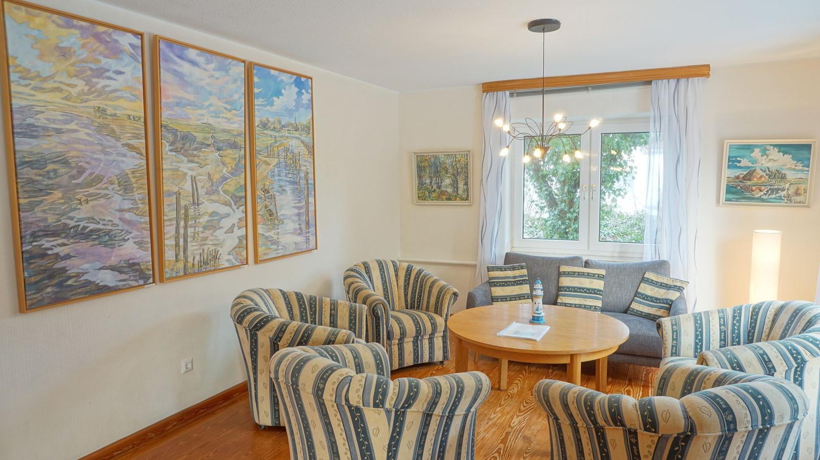 Wohnzimmer mit Sitzgruppe, Tisch und Wandbildern