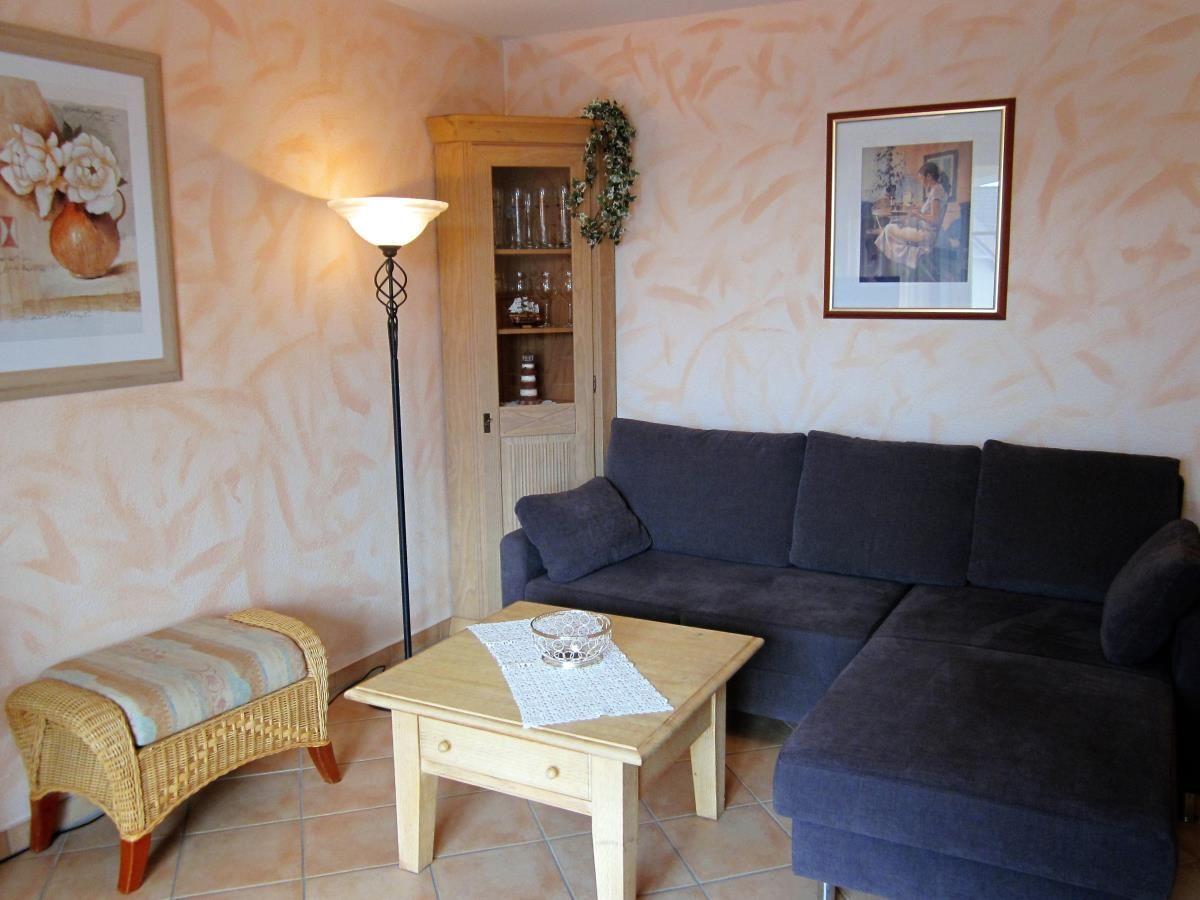 Wohnzimmer mit Sofa, Couchtisch und Stehlampe. Wandbild und Holzregal sichtbar.