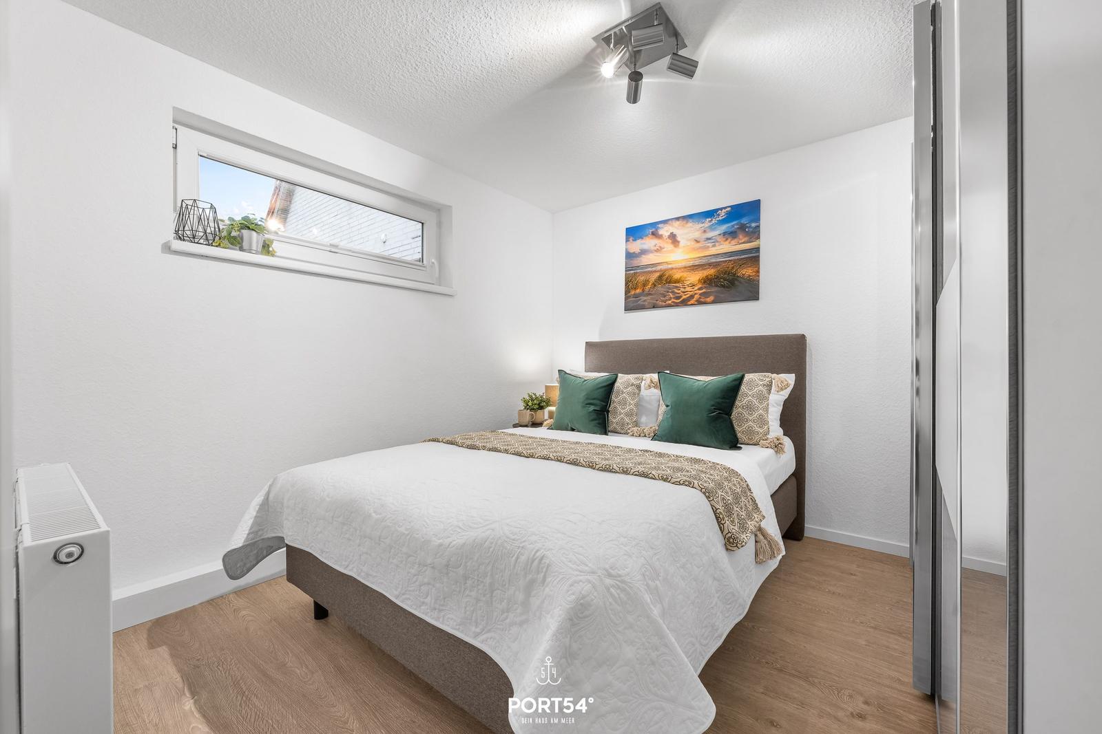 Schlafzimmer mit Bett, Wandbild und Fenster