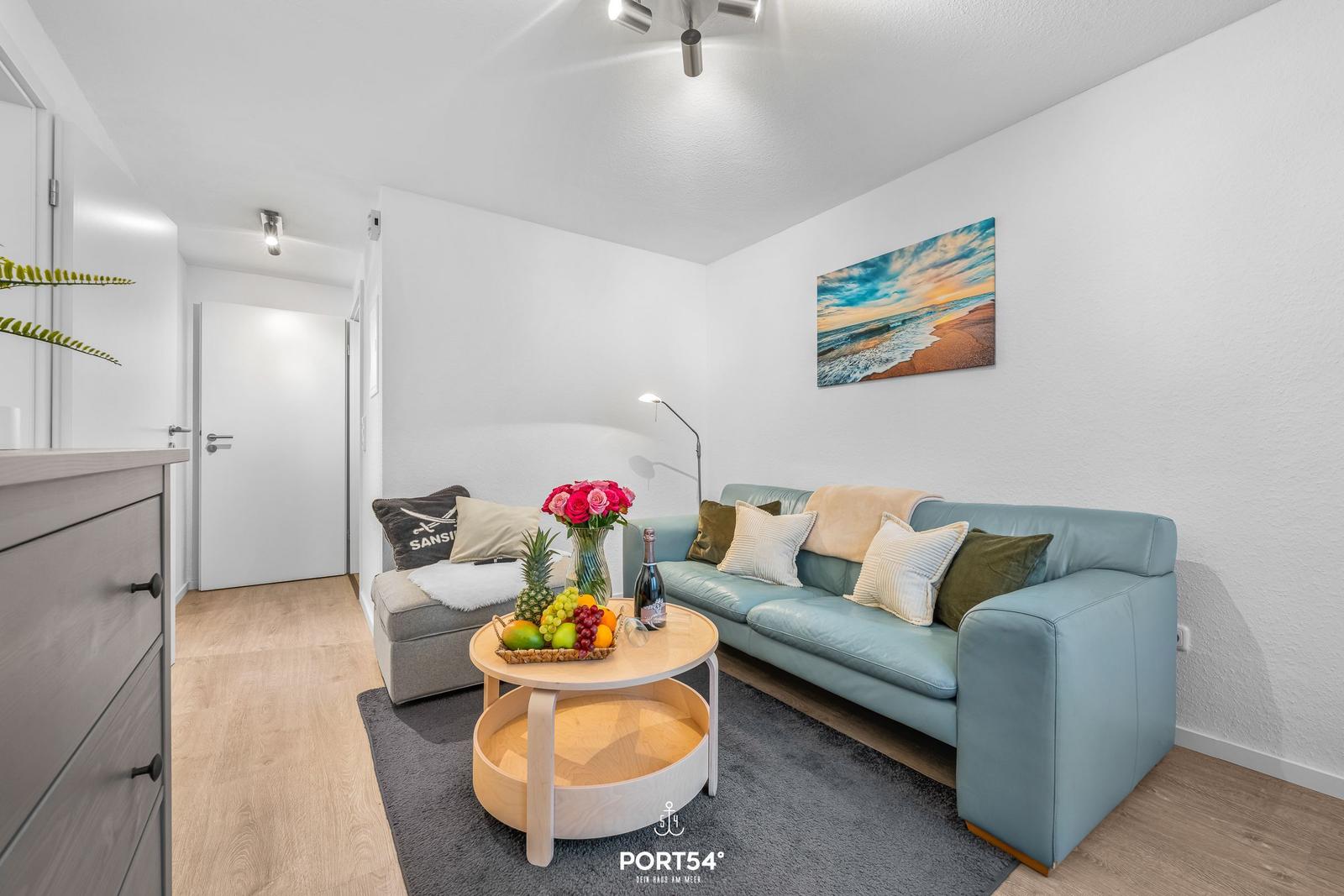 Wohnzimmer mit Sofa, Couchtisch und Wandbild