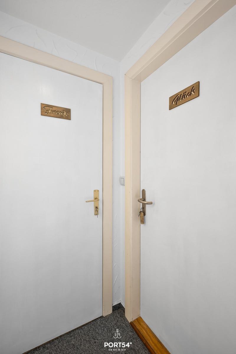 Zwei Türen mit Schildern: Freunde und Glück. Weiße Türen mit goldenen Griffen.