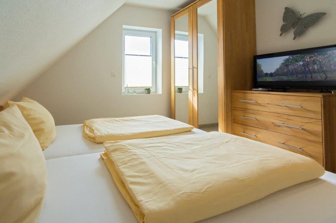 Schlafzimmer mit Doppelbett, Schrank und Fernseher