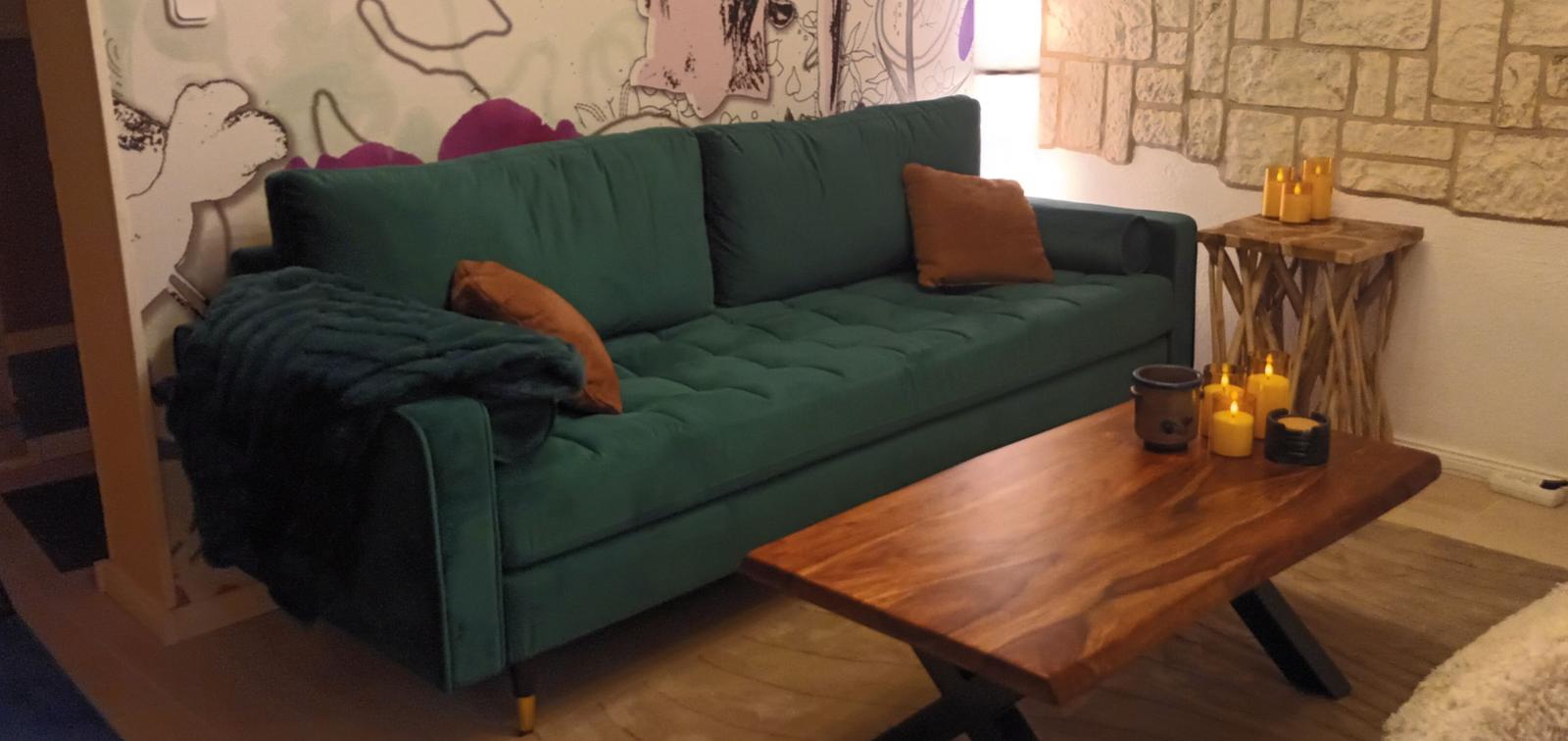 grünes Samtsofa im Wohnzimmer