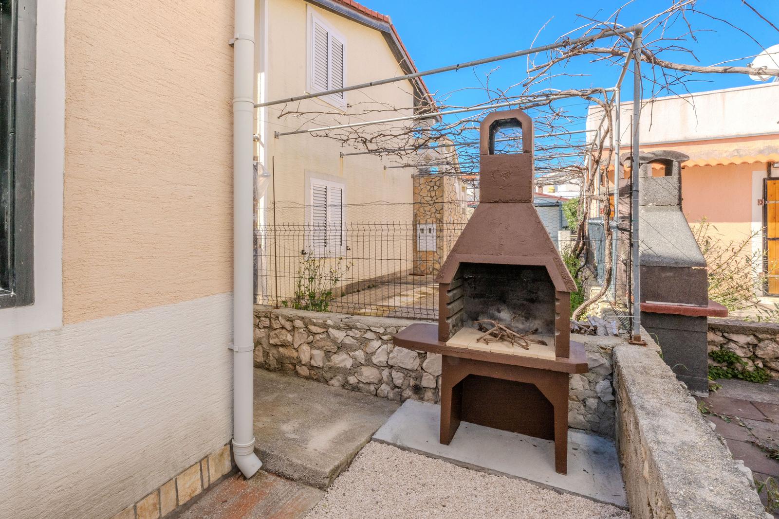 Outdoor area with grill and stone wall