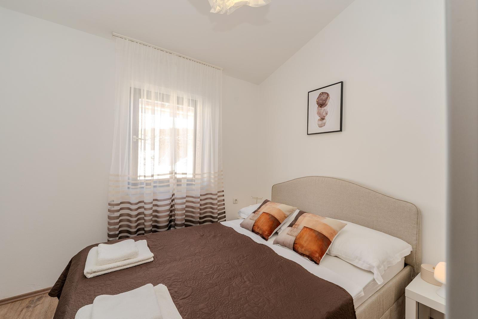 Bedroom with bed, window, and nightstand