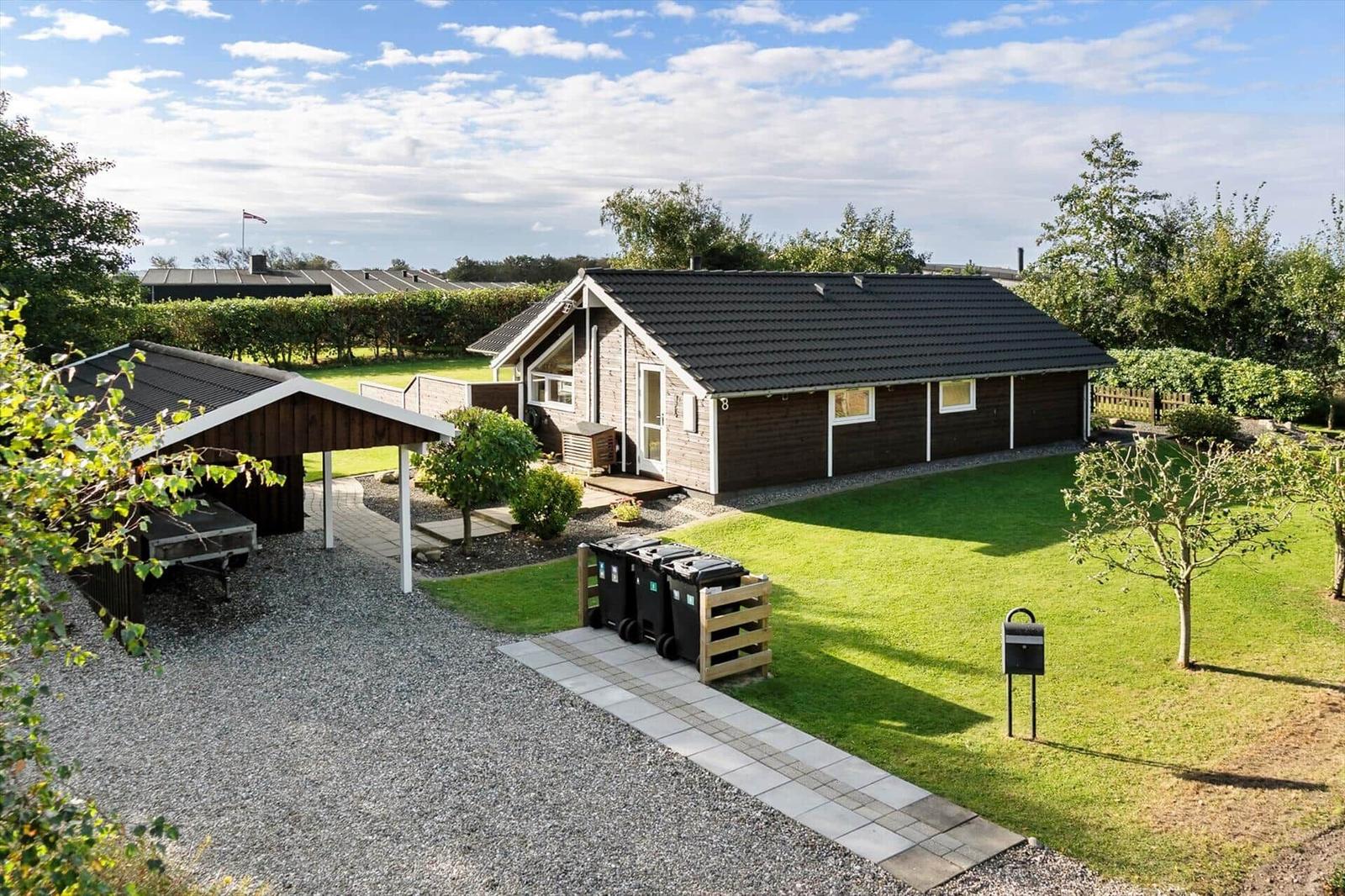 Holzhaus mit Garten, Grillplatz und Parkplatz. Hinterhof mit Hecke und Bäumen.