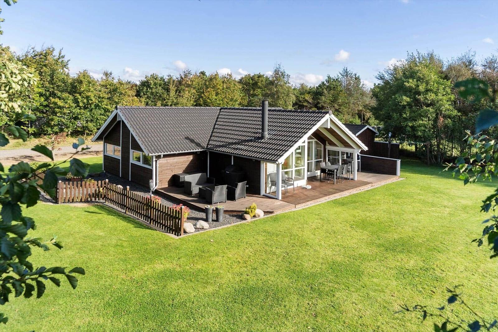 Holzhaus mit Terrasse, Garten und Grillplatz im Grünen.