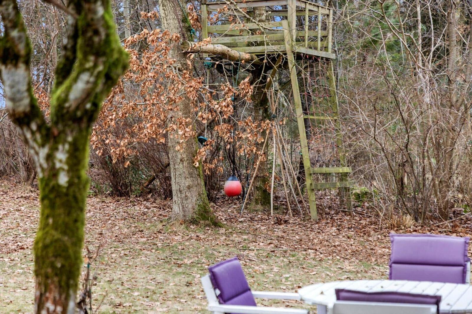 Hinterhof mit Baumhaus, Tisch und Stühlen im Wald.
