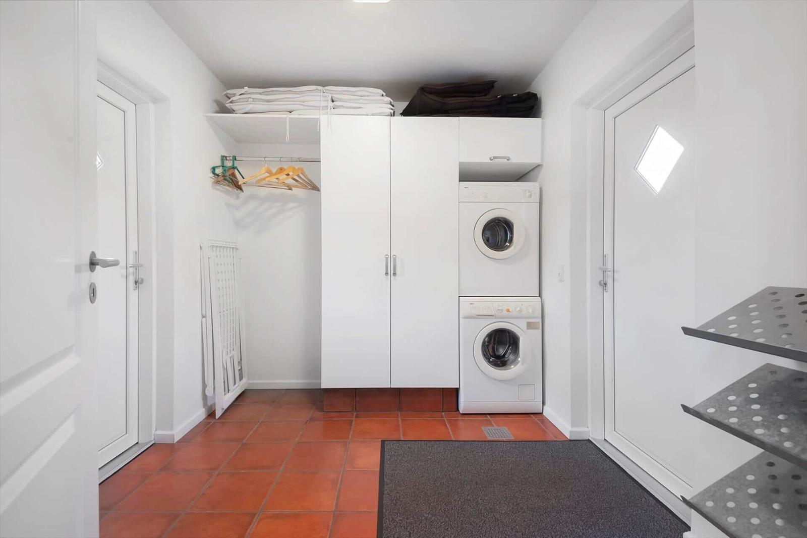 Laundry room with washer and dryer, closet, and tile floor.