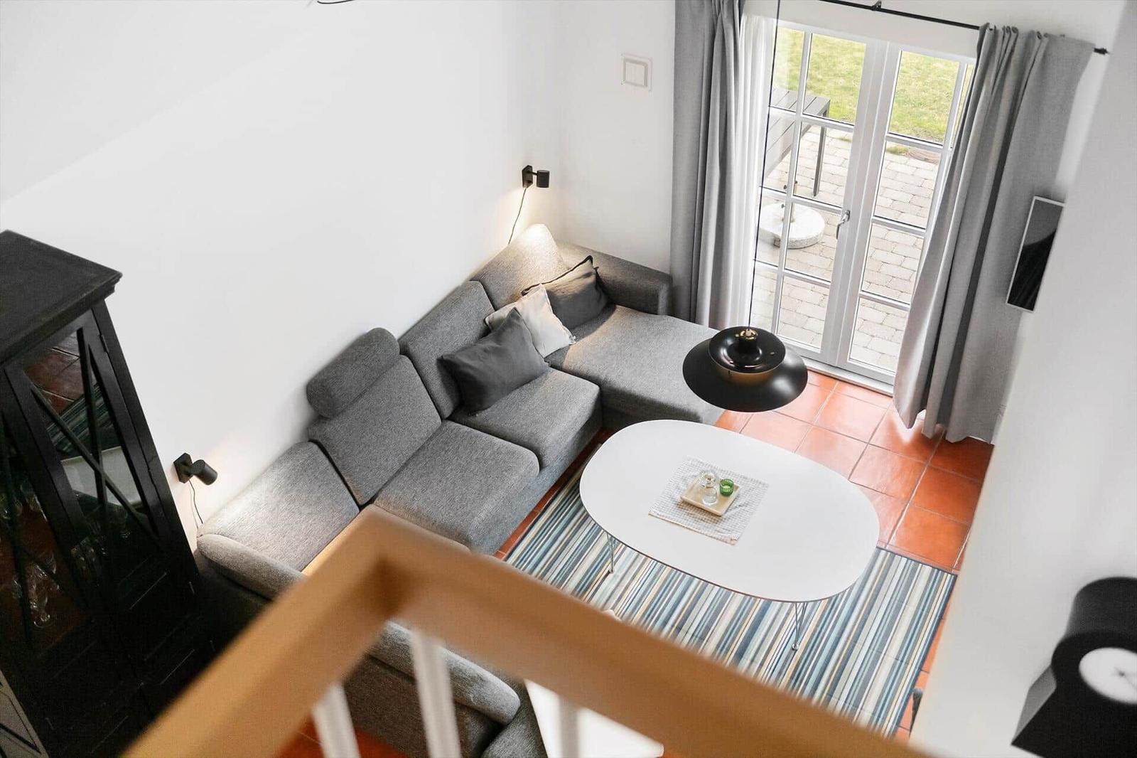 Living room with gray sofa, white table, and terrace door.