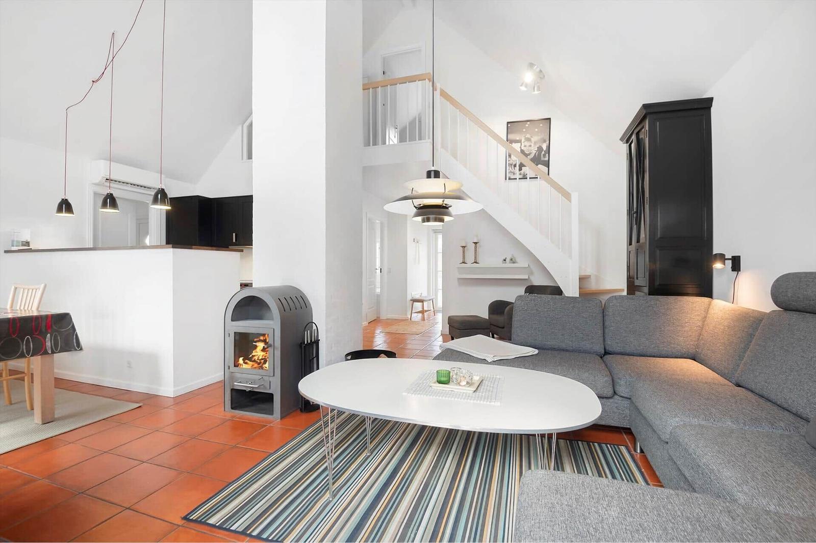 Living room with sofa, fireplace, and staircase to upper level.