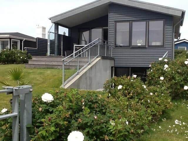 Moderne Villa mit Terrasse und Stufen zur Eingangstür.