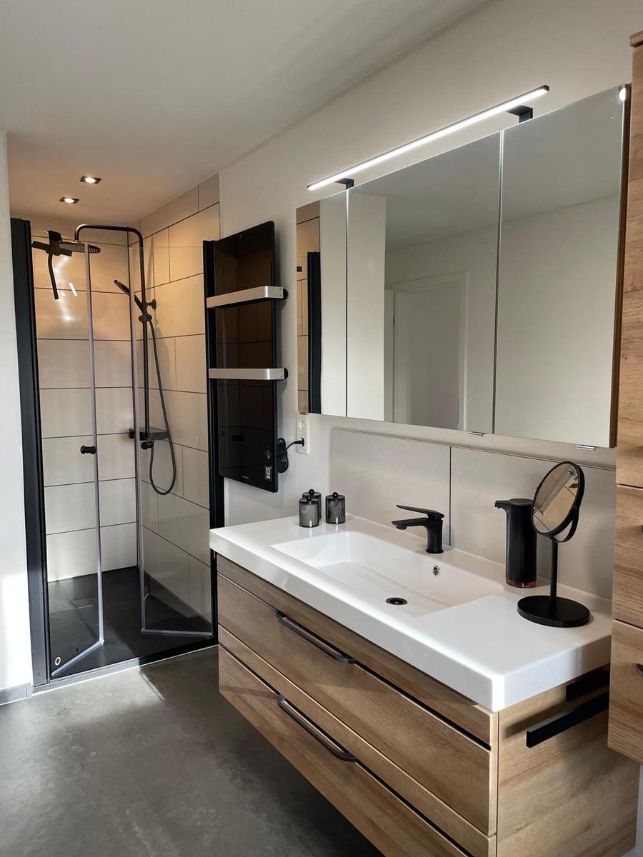 Moderne Badezimmer mit Dusche, Waschbecken und Spiegelschrank.