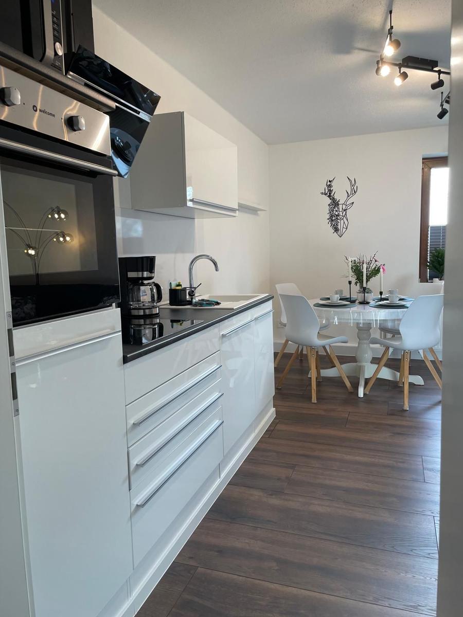 Moderne Küche mit Essbereich und Tisch für vier Personen.