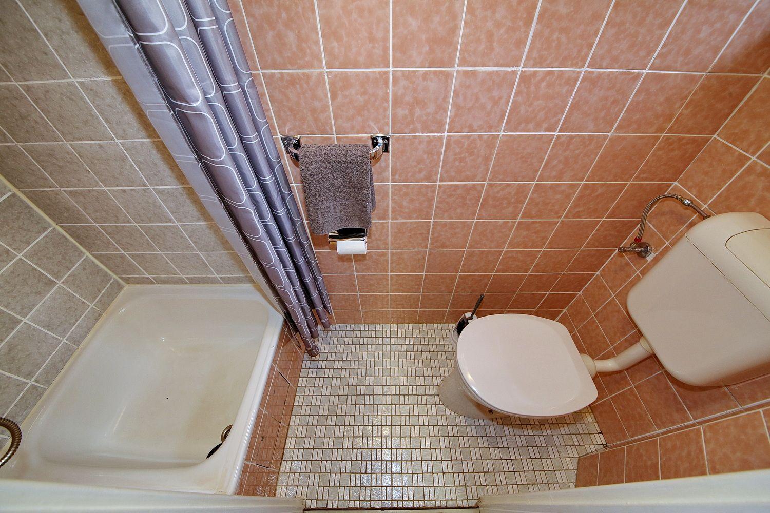 Badezimmer mit Dusche, Toilette und Handtuchhalter