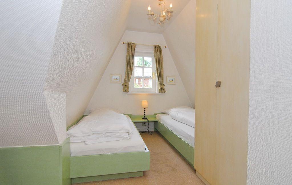 Zimmer mit zwei Betten, Fenster und Deckenbalken.