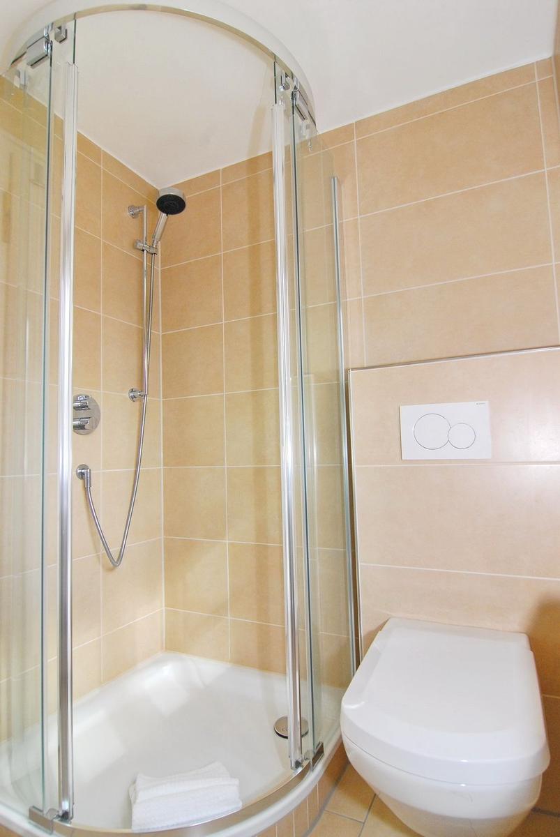 Duschbad mit Dusche, Toilette und Handtuch