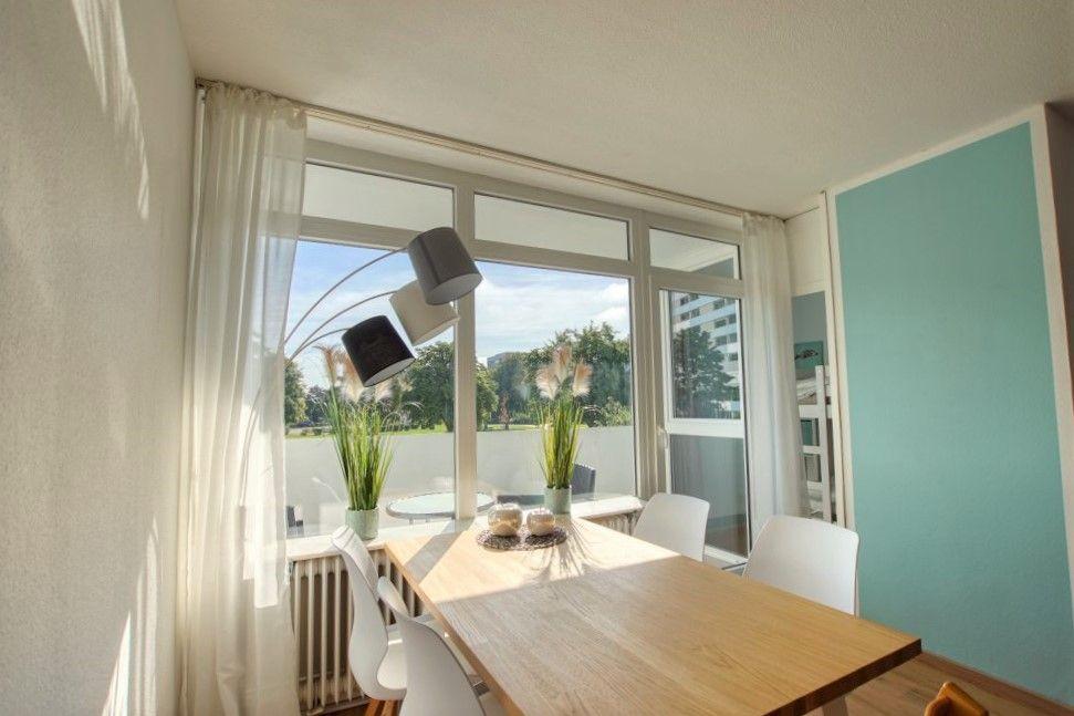Essbereich mit Tisch, Stühlen und großem Fenster zur Terrasse