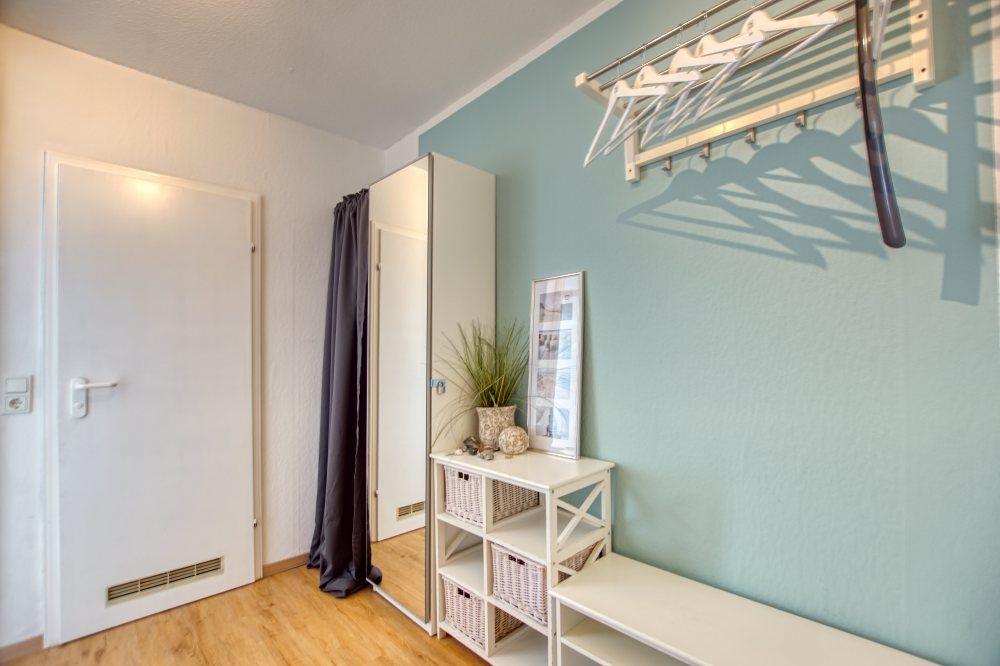 Raum mit Tür, Kleiderständer und Regal mit Körben.