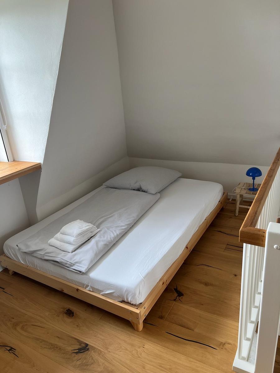 Ein Schlafzimmer mit einem Bett, einem Nachttisch und einer Lampe.