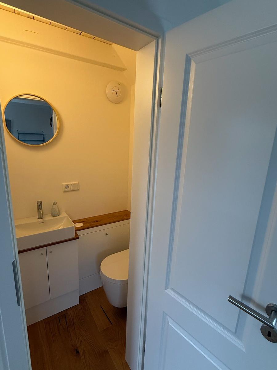 Badezimmer mit Waschbecken, Spiegel und Toilette
