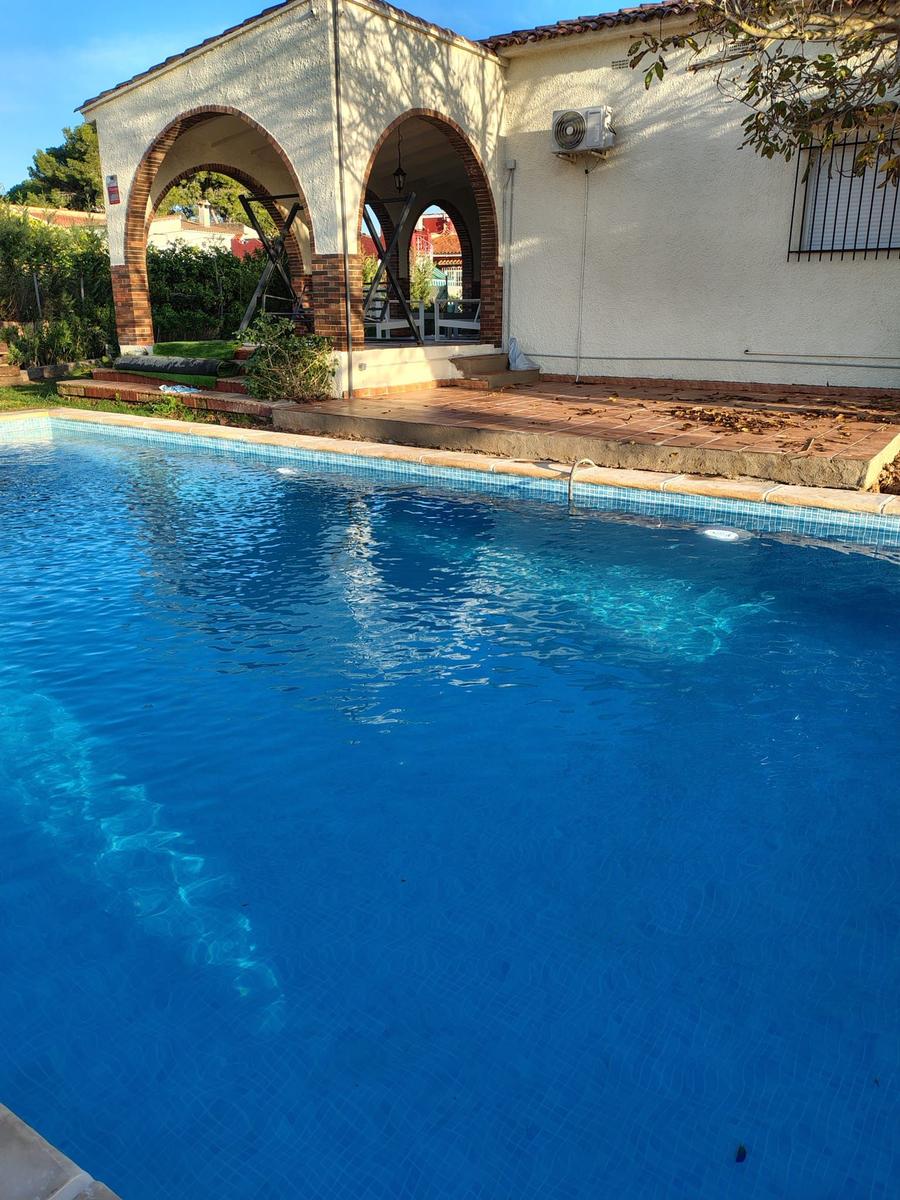 Pool mit Blick auf Terrasse und Bogenarkadenhaus