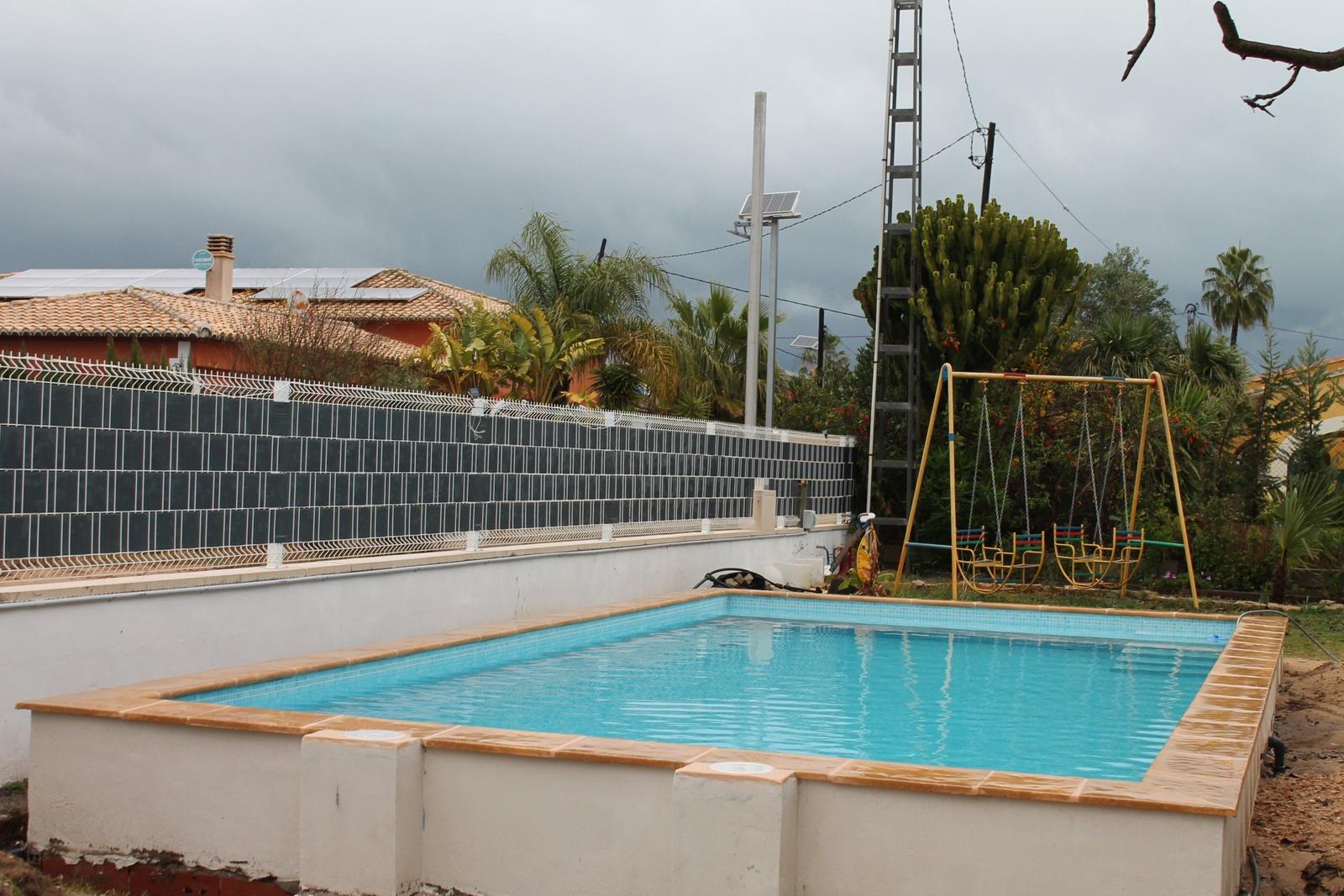 Pool mit Spielplatz und Umzäunung im Hintergrund