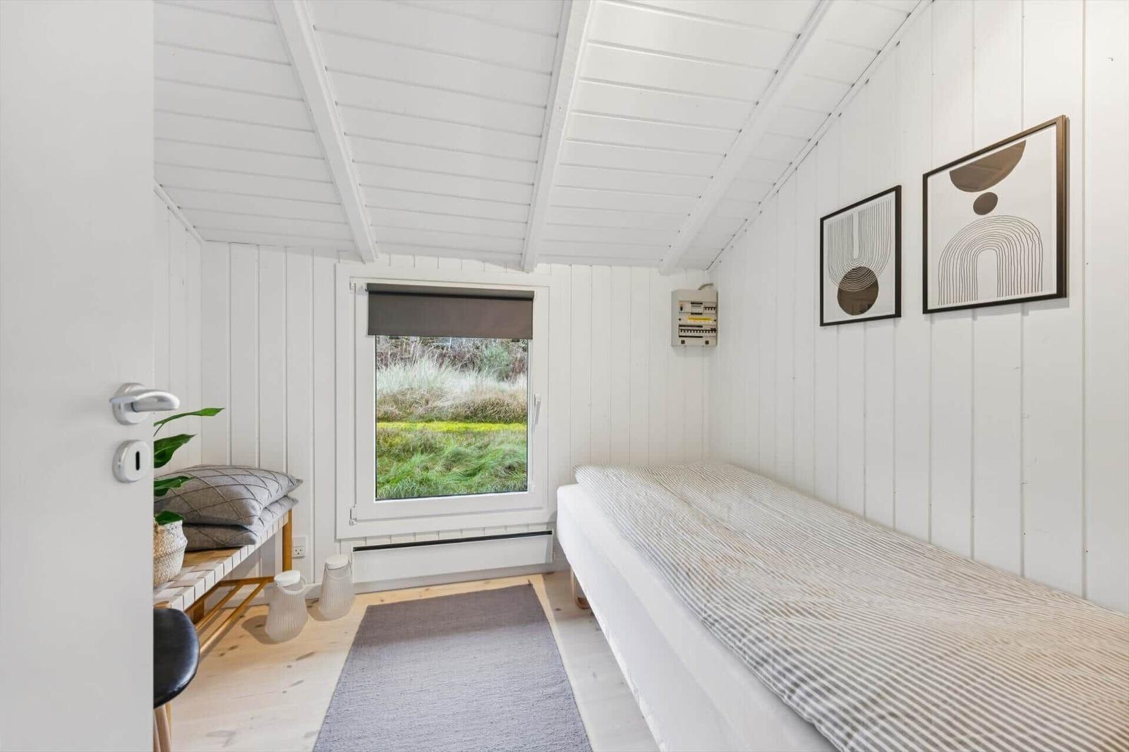 Bedroom with bed, window, and wall art.