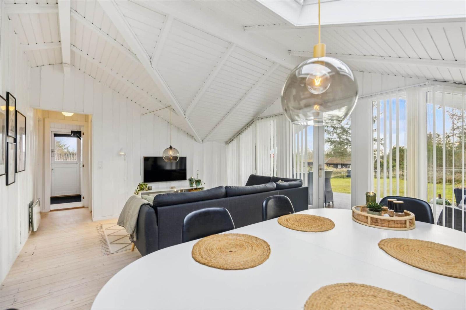 Living and dining area with white wood, sofa, and dining table.