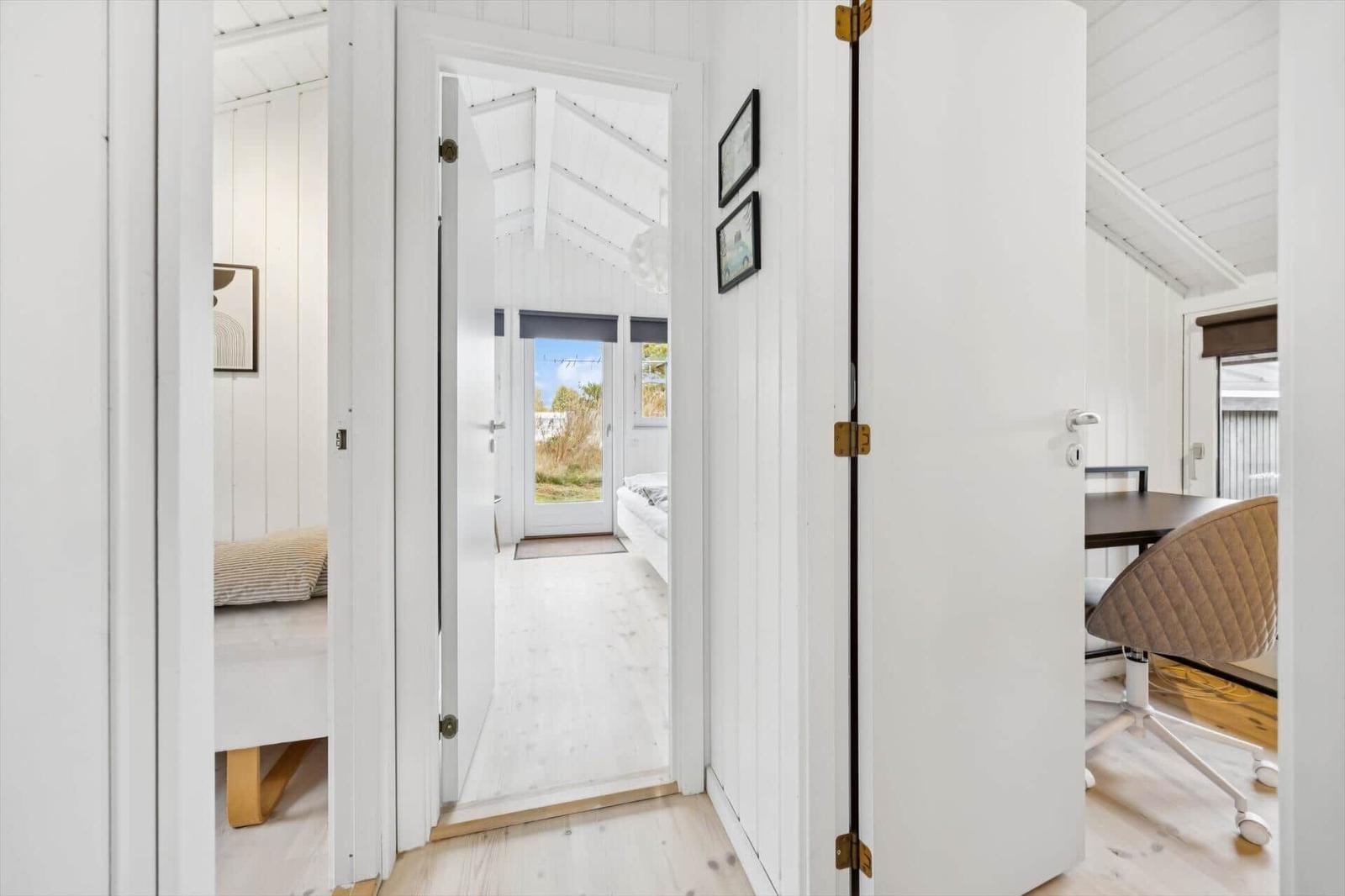 Bright rooms with white walls and wooden floors. Corridor to sleeping and working areas.