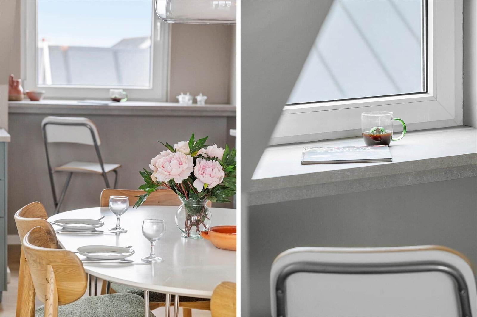 Dining room with table, chairs, and flowers. Windowsill with mug and book.