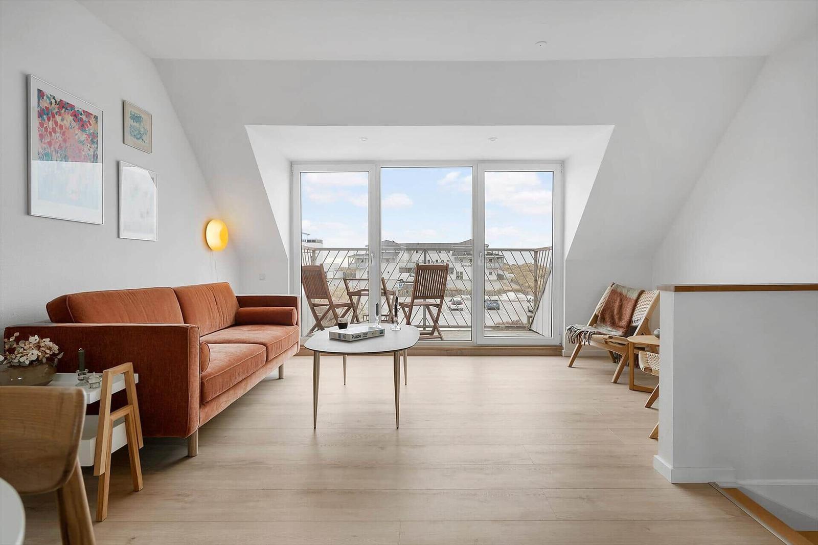 Living room with sofa, table, and balcony view