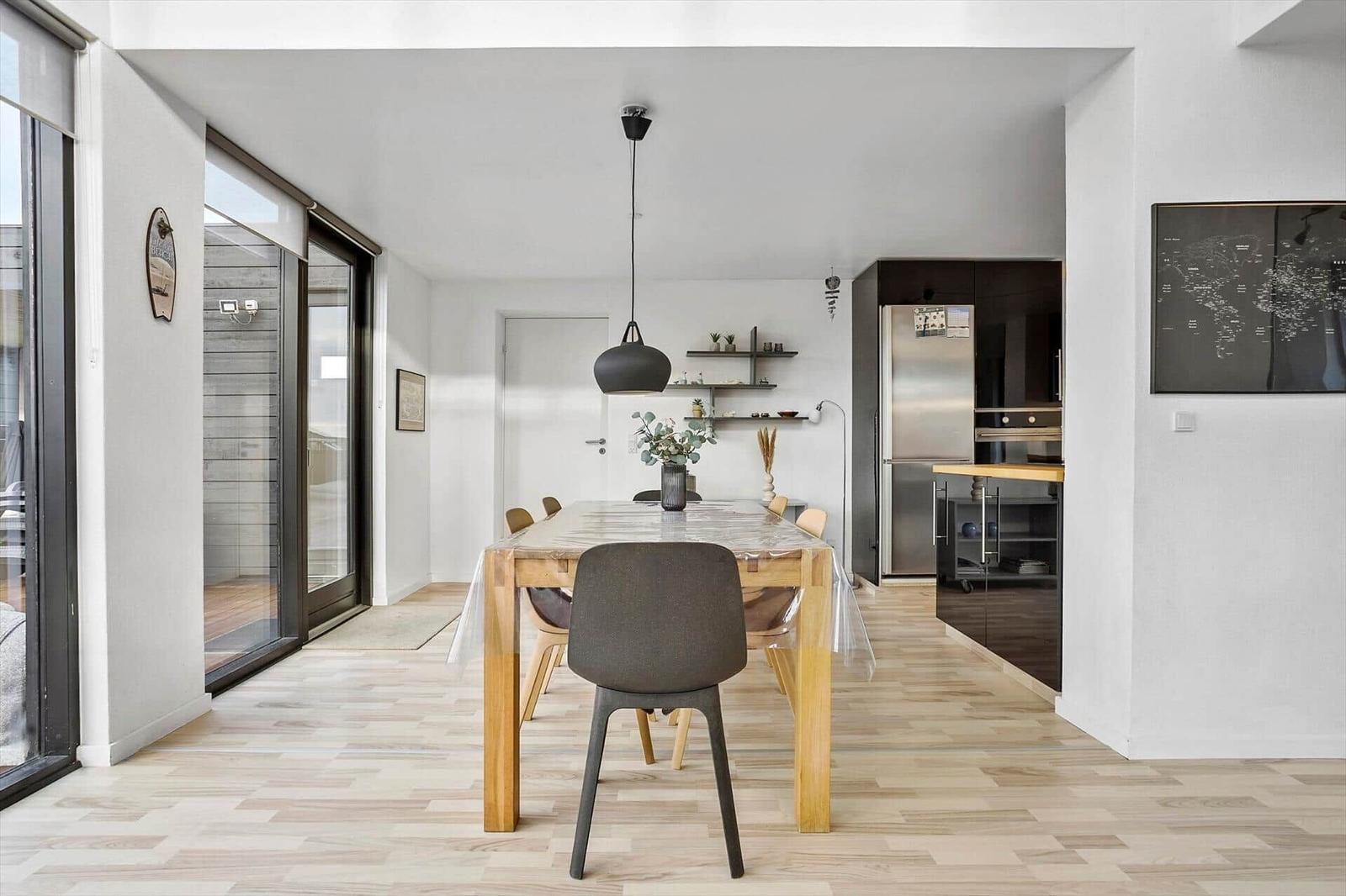 Dining room with table, chairs, and view of the kitchen.