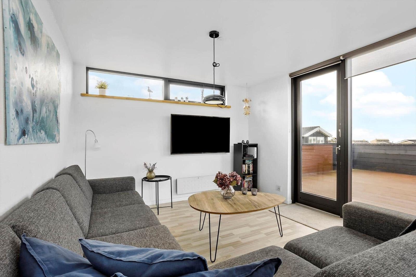 Living room with sofa, TV, and terrace door.