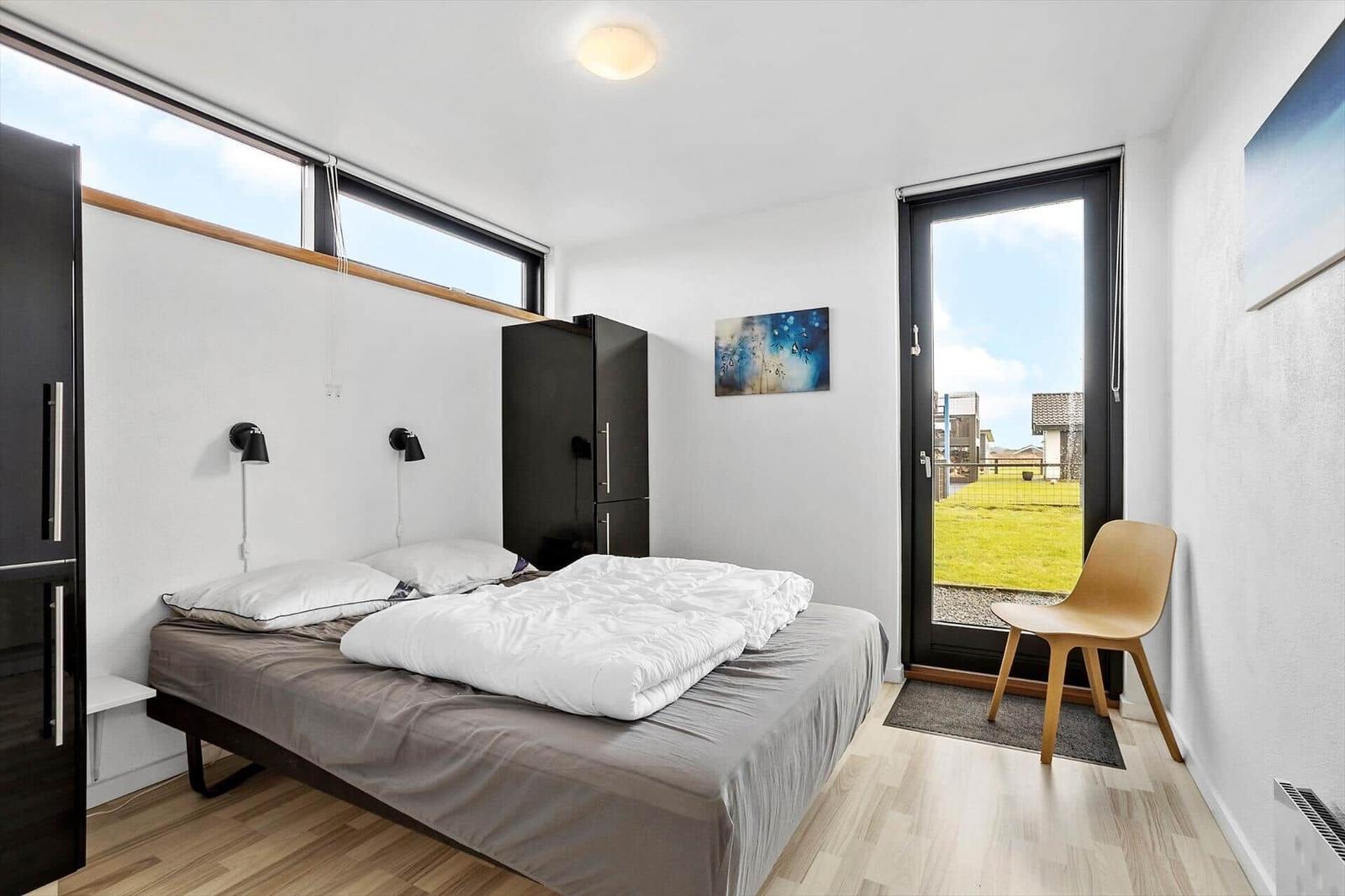 Bedroom with bed, wardrobe, and door to the garden.
